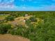 Sprawling property featuring multiple structures amid green fields and mature trees, offering privacy and space at 6321 279Th E St, Myakka City, FL 34251