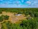 Overhead view of a charming home nestled in a verdant landscape, accented by tranquil pond and open fields at 6321 279Th E St, Myakka City, FL 34251