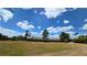 Spacious lot features a large metal barn and mature landscaping under a beautiful cloudy sky at 6321 279Th E St, Myakka City, FL 34251