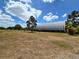 Vast lot features a sizable metal barn, mature landscaping and a clear, sunny sky at 6321 279Th E St, Myakka City, FL 34251