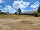 Large lot features a sizable metal barn, mature landscaping and a clear, sunny sky at 6321 279Th E St, Myakka City, FL 34251