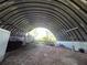 Interior of a metal barn with a dirt floor, open space, and natural light coming from the entrance at 6321 279Th E St, Myakka City, FL 34251