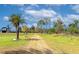 Gravel driveway leads to the property, framed by mature palm trees and lush greenery at 6321 279Th E St, Myakka City, FL 34251