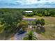 Aerial view of a house with lush landscaping, a large barn, and a paved parking area at 6321 279Th E St, Myakka City, FL 34251
