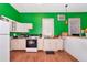 Efficient kitchen with white cabinets, appliances, and green walls, illuminated by a window at 6321 279Th E St, Myakka City, FL 34251