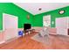 Bright living room with vibrant green walls, wood-look floors, and cozy seating area at 6321 279Th E St, Myakka City, FL 34251