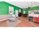Open floor plan combining a seating area, dining space, and kitchenette with green walls at 6321 279Th E St, Myakka City, FL 34251