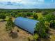 Large storage building with a metal roof surrounded by lush greenery on a sprawling property at 6321 279Th E St, Myakka City, FL 34251