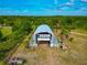 Aerial view of a metal storage building with open access points surrounded by trees and foliage at 6321 279Th E St, Myakka City, FL 34251