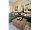 Comfortable living room featuring a large sectional sofa, textured ottoman, and decorative mirrors at 6368 Draw Ln # 34, Sarasota, FL 34238