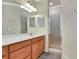 Bathroom with single sink vanity, wood cabinets, a walk-in shower with a glass door, and hooks at 6406 Grand Estuary Trl # 102, Bradenton, FL 34212