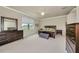 Primary bedroom suite with a large bed, sitting bench, dresser, and a sun-filled window at 6406 Grand Estuary Trl # 102, Bradenton, FL 34212