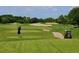 Scenic golf course view featuring manicured fairways and a golfer mid-swing at 6406 Grand Estuary Trl # 102, Bradenton, FL 34212