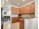 Kitchen featuring granite countertops, wood cabinets, stainless steel appliances, and tile backsplash at 6406 Grand Estuary Trl # 102, Bradenton, FL 34212