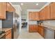 Kitchen featuring stainless steel appliances, granite countertops, and wood cabinetry at 6406 Grand Estuary Trl # 102, Bradenton, FL 34212