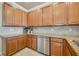 Kitchen featuring granite countertops, stainless steel dishwasher, and light wood cabinetry at 6406 Grand Estuary Trl # 102, Bradenton, FL 34212