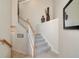An open staircase featuring carpeted steps and a white wood railing with a welcome sign on the wall at 6406 Grand Estuary Trl # 102, Bradenton, FL 34212