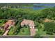 A beautiful lakefront home with a red tile roof, surrounded by lush landscaping and mature trees at 6612 Butlers Crest Dr, Bradenton, FL 34203