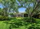 Expansive backyard with lush landscaping, mature trees, and a screened-in patio, offering privacy and tranquility at 6612 Butlers Crest Dr, Bradenton, FL 34203