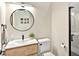 Small bathroom with dark trim features wood vanity, round mirror, shower and neutral paint at 6612 Butlers Crest Dr, Bradenton, FL 34203