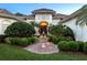 Inviting home entrance with lush landscaping, a tranquil water fountain, and an elegant arched doorway at 6612 Butlers Crest Dr, Bradenton, FL 34203
