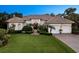 Charming home with manicured lawn, fountain, mature landscaping, brick driveway, and a two-car garage at 6612 Butlers Crest Dr, Bradenton, FL 34203