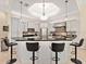 Bright open kitchen featuring white cabinetry, black countertops, stainless appliances, tile backsplash, and bar stool seating at 6612 Butlers Crest Dr, Bradenton, FL 34203