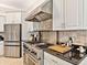 Modern kitchen with stainless steel appliances, custom cabinets, black countertops, and stone backsplash at 6612 Butlers Crest Dr, Bradenton, FL 34203