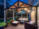 Stylish covered patio with cozy seating, ambient string lights, and scenic views of the well-manicured backyard at 6612 Butlers Crest Dr, Bradenton, FL 34203