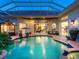 Inviting outdoor pool area with clear enclosure, comfortable seating, and views of interior living spaces at 6612 Butlers Crest Dr, Bradenton, FL 34203