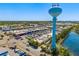 Panoramic aerial view of the community showcasing commercial properties, water tower, lush greenery, and pond at 7201 Curtiss Ave # 2D, Sarasota, FL 34231