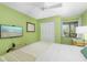 This bedroom boasts a flatscreen television, closet, a comfortable bed and light green walls at 7201 Curtiss Ave # 2D, Sarasota, FL 34231