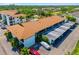 A bright exterior daytime shot of a multi-unit dwelling with covered parking, pool, and tropical landscaping at 7201 Curtiss Ave # 2D, Sarasota, FL 34231