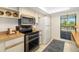 The bright kitchen has white cabinets, wooden countertops, stainless appliances, and direct access to a balcony at 7201 Curtiss Ave # 2D, Sarasota, FL 34231