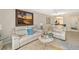 A living room features a decorative rug, white couches, and views of the dining room at 7201 Curtiss Ave # 2D, Sarasota, FL 34231