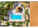 Overhead view of a community pool with a gazebo, lounge chairs, and tropical landscaping at 7203 Curtiss Ave # 3D, Sarasota, FL 34231