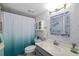 Well-lit bathroom featuring vanity with modern lighting, toilet and a shower with an ombre curtain at 7203 Curtiss Ave # 3D, Sarasota, FL 34231