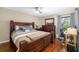 Spacious bedroom with wooden frame bed, ceiling fan, and large window offering natural light at 7203 Curtiss Ave # 3D, Sarasota, FL 34231