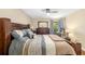 Spacious bedroom with wooden frame bed, ceiling fan, desk area, and large dresser at 7203 Curtiss Ave # 3D, Sarasota, FL 34231