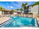 Community pool with clear blue water, palm trees, and comfortable seating at 7203 Curtiss Ave # 3D, Sarasota, FL 34231