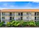 Exterior view of condo building with multiple units, balconies, and lush landscaping on a bright day at 7203 Curtiss Ave # 3D, Sarasota, FL 34231