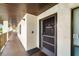 Exterior front door with a welcoming welcome sign, screen door, and security features at 7203 Curtiss Ave # 3D, Sarasota, FL 34231