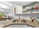 Modern kitchen featuring granite countertops, a stainless steel sink, and stylish open shelving at 7203 Curtiss Ave # 3D, Sarasota, FL 34231