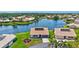 An aerial shot of a single Gathering home and its manicured lawn near a serene lake at 75 Inlets Blvd # 75, Nokomis, FL 34275