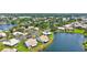 Stunning aerial view of lakeside homes with manicured lawns in a lovely community with mature trees at 75 Inlets Blvd # 75, Nokomis, FL 34275