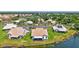 An aerial view of a single Gathering home with lush green yard and a tranquil lake at 75 Inlets Blvd # 75, Nokomis, FL 34275