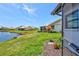 Beautiful backyard with a view of the lake, lush green grass, and flower beds at 75 Inlets Blvd # 75, Nokomis, FL 34275