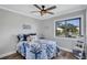 Light-filled bedroom with ceiling fan, view of the neighborhood and laminate flooring at 75 Inlets Blvd # 75, Nokomis, FL 34275