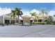Community clubhouse featuring a well-manicured entrance with lush landscaping and ample parking at 75 Inlets Blvd # 75, Nokomis, FL 34275