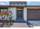 Inviting front entrance with a well-kept lawn, beautiful landscaping, and a dark two-door garage at 75 Inlets Blvd # 75, Nokomis, FL 34275